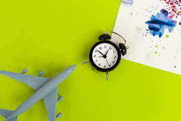 Time to travel concept. plastic plane jet toy passenger with alarm clock