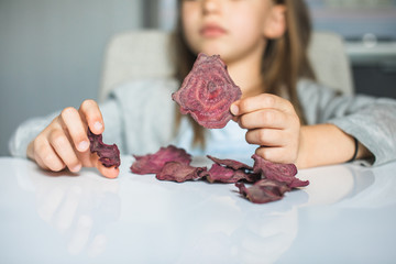 Cheeky cute blond little girl playing with dried fruit