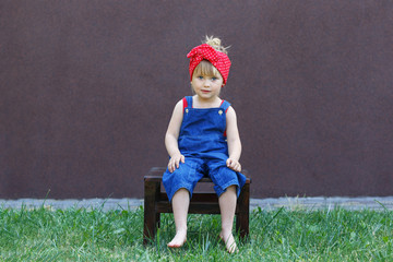 Little girl with polka-dot headband laughs and looks at the viewer.