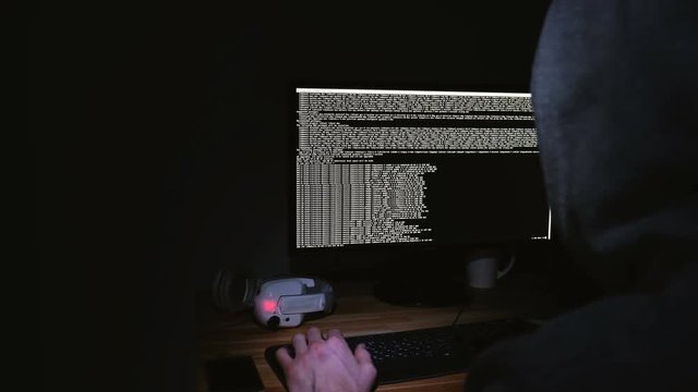 Hacker programs on the command line, the monitor glows in the dark, 4k