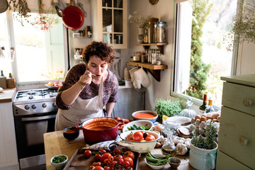 Woman tasting a tomato soup