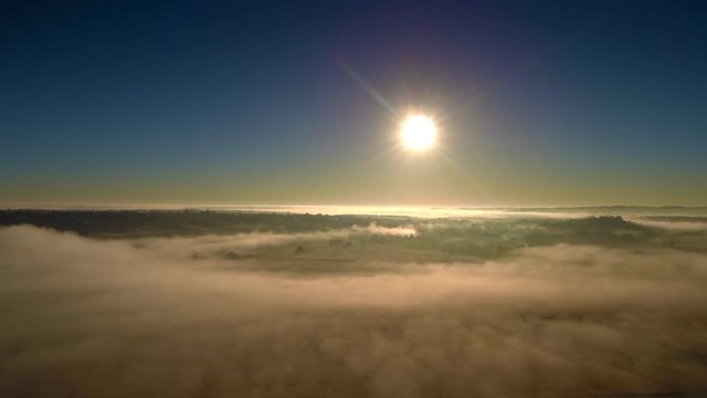 Backward drone ascending flight over the field reveals foggy fields perspective. FullHD 1080p.