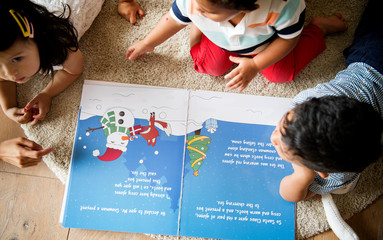 Young kids reading a Christmas story together © Rawpixel.com