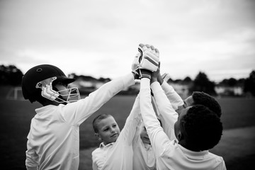 Group of young cricketers doing a high five