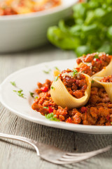 Italian pasta Conchiglioni Rigati stuffed with dry tomatoes and meat.