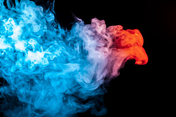 A multi-colored pattern of blue and red smoke of a mystical shape in the form of a face and a ghost's head or a strange creature on a black isolated background. Abstract pattern in of waves and steam