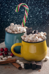 Mugs of hot chocolate with marshmallow on background of chocolate and cinnamon. Warm Christmas home holiday