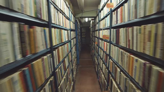 Slow camera movement between two archive shelves filled with folders.