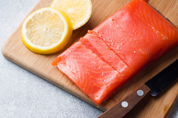 Fresh salmon fillet with lemon on a cutting Board.