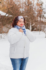 Fototapeta na wymiar Plus size elegant woman at winter day in park walking outdoor, plump lady lifestyle. XXL lady in coat, magic cold Christmas time, warm clothes and fashion accessorize 