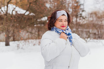 Plus size elegant woman at winter day in park walking outdoor, plump lady  lifestyle. XXL lady in coat, magic cold Christmas time, warm clothes and fashion accessorize  