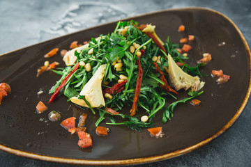 Vegetarian salad with mushrooms, pine nuts, pepper and tomatoes