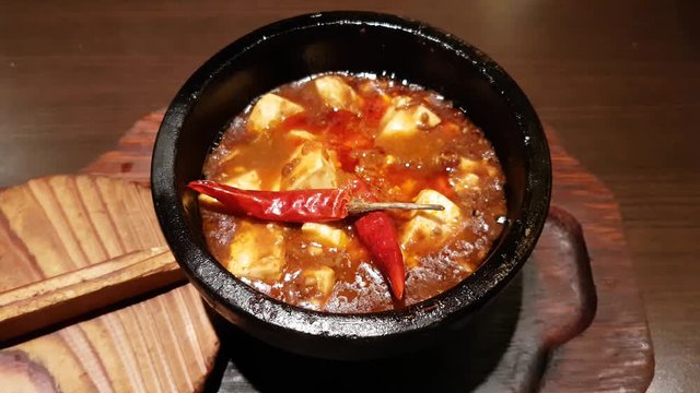 Tofu cheese. Red pepper. Very hot dish. Spicy vegetarian dish. In boiling broth