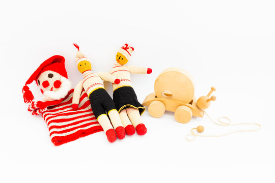 Front view of funny vintage children toys on white background. Assortment consists of a clown, a male doll, a female doll, and a wooden snail.