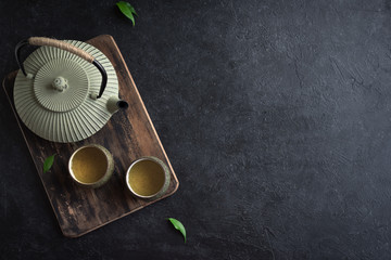 Teapot and teacups on black table