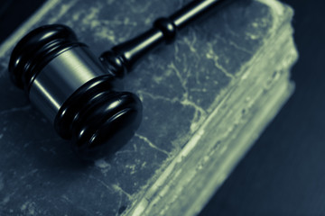 Judge gavel beside pile of books on wooden background