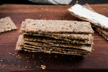 Useful rye crispbread on a wooden board against a dark background