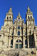 Fototapeta na wymiar Cathedral, Santiago de Compostela, Obradoiro Square. Spain. Baroque facade, old iron gate and towers. Clean stone, sunny day.