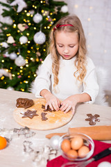 cute little girl cooking Christmas cookies in kitchen