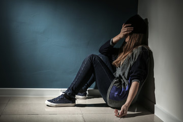 Female junkie with syringe sitting on floor. Concept of addiction
