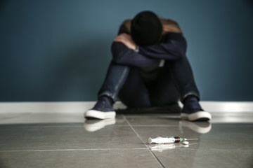 Syringe and drugs of female junkie on floor. Concept of addiction