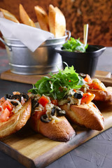 Crispy toasts with tomato, olives, arugula and cheese