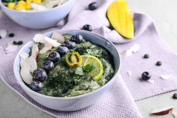 Bowl with tasty spirulina smoothie on grey table