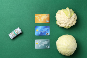 Fresh cabbage with dollars and credit cards on color background, flat lay