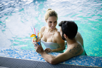 Happy attractive couple relaxing in swimming pool