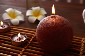 Beautiful burning candles on bamboo mat