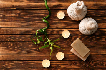 Beautiful spa composition with burning candles and soap bars on wooden table
