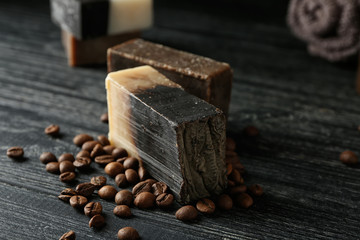 Soap bars with coffee beans on dark wooden table