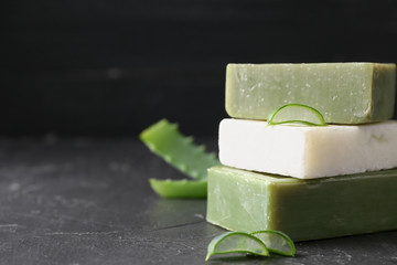 Soap bars with aloe vera on dark table
