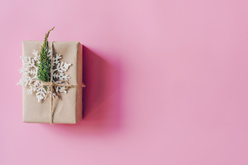 Brown gift box on the pink background. Minimal styled holiday card with copy space.