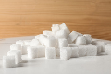 Heap of refined sugar cubes on table