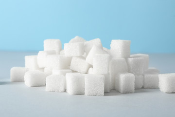 Heap of refined sugar cubes on table