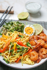 Tasty chinese noodles, shrimps and vegetables on plate, closeup