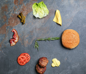 Flat lay composition with ingredients for burger on grey background