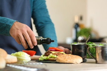 Male chef preparing burger in kitchen