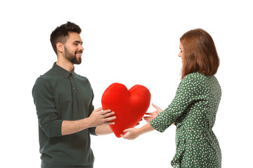 Fototapeta na wymiar Young man giving fabric heart to his beloved girlfriend on white background. Celebration of Saint Valentine's Day