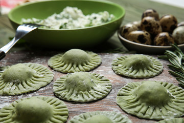 Raw ravioli on wooden board, closeup