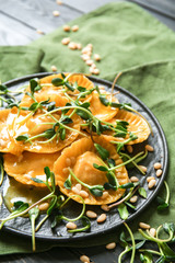 Plate with tasty ravioli on table, closeup