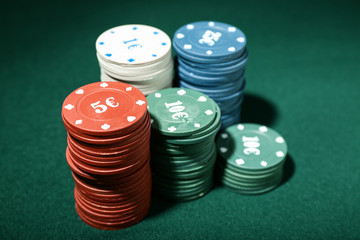 Chips for poker game on green table