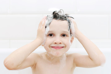Little boy washes his hair with shampoo
