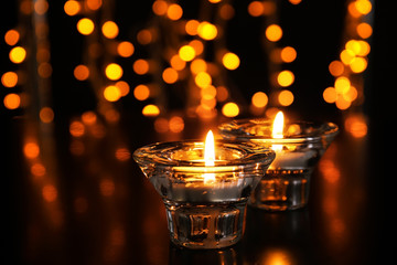 Burning candles against blurred lights