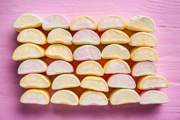 Tasty sweet marshmallows on color wooden table