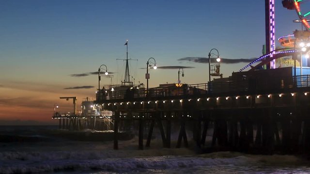 Waves crahing into the Santa Monica Pier after sundown