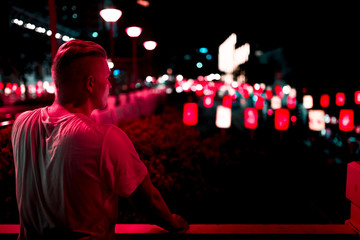 Mann vor Neon Reklame bei Nacht