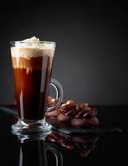  Chocolate dessert with hazelnut and coffee with cream on a black background.