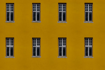 Closeup photo of bright yellow building with eight windows, seamless tiling texture
